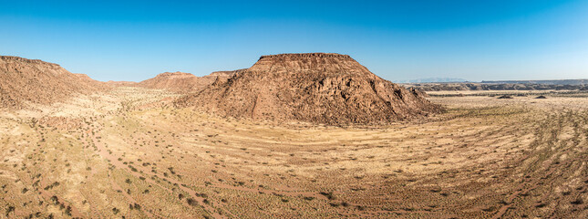 This high-quality drone photograph presents a sweeping aerial round flight over the dramatic landscapes of Namibia, offering a breathtaking bird’s-eye view of one of the world’s oldest deserts. The ca
