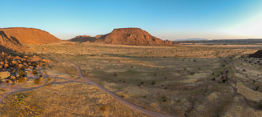 This high-quality drone photograph presents a sweeping aerial round flight over the dramatic landscapes of Namibia, offering a breathtaking bird’s-eye view of one of the world’s oldest deserts. The ca