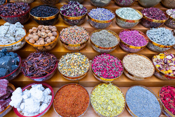 Traditional spices market. Pots and wooden tubs stand in row with colorful tea, spices, fruits, roots, flowers. Street bazaar.