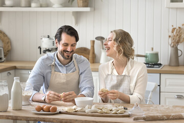 Cooking is hobby not chores. Joyful family couple preparing homemade dumplings for breakfast laughing chatting spending pleasant time together in kitchen turn daily culinary routine into fun teamwork