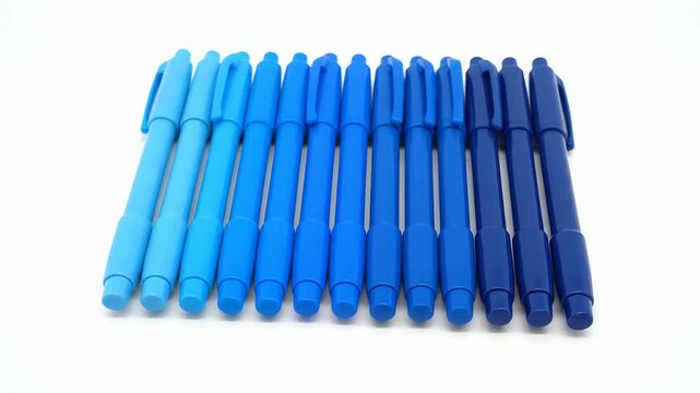 A vibrant collection of blue pens arranged in a neat color gradient on a clean white background.