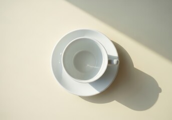 Minimalist White Coffee Cup and Saucer on Cream Surface with Sunlight and Shadows