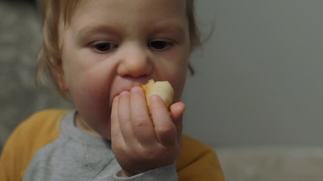 A child enjoys a delicious bun, embodying the purity of innocent childhood moments. Close-up, selective focus