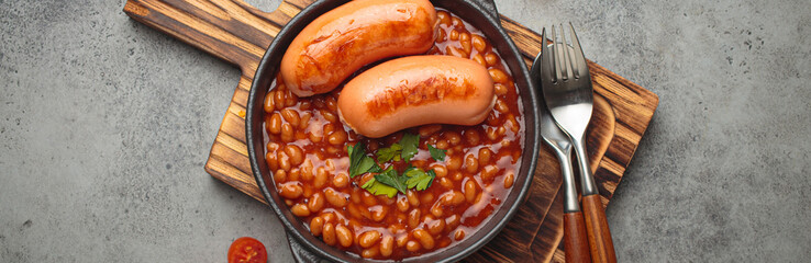 Baked beans tomato sauce grilled sausages cast iron pan English breakfast