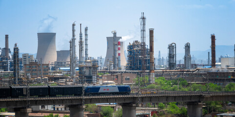 Obraz premium A Coal Freight Train Passing Through an Industrial Zone