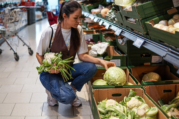 dark-haired middle-aged woman shopping for fruits and vegetables in a supermarket