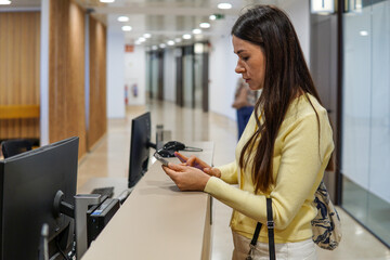 middle-aged woman registering at reception desk in medical or administrative building