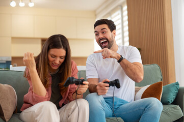 Obraz premium Young couple laughing playing competitive video games