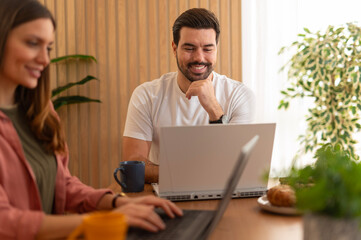 Couple working on laptops from home office