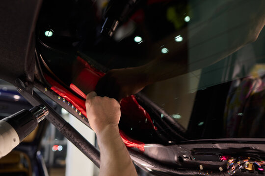 The Professional Windshield Tinting Process Conducted in a Modern Auto Showroom Environment