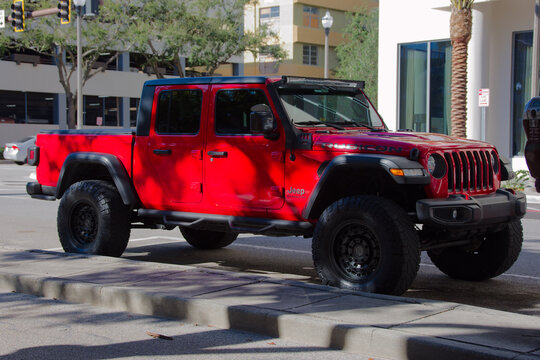 Red Jeep Rubicon Truck Parked On City Street Showcasing Rugged Off-Road Adventure. Editorial Use Only. Dec 12,2025 St. Petersburg, FL USA. Bright red Jeep parked along a curb in an urban area. The rug