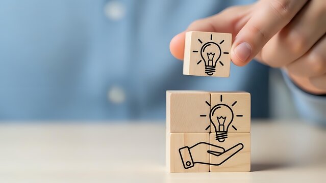 Hand stacking wooden blocks with lightbulb icons representing creative ideas, innovation and business solution concepts for brainstorming sessions. - Powered by Adobe
