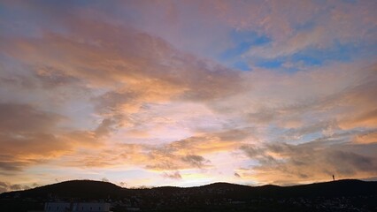 Obraz premium Beautiful sunset with yellow clouds in blue sky over the mountain