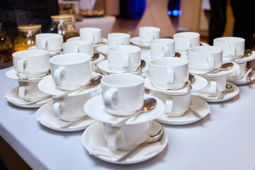 Elegant table setting, Refined display of fine china for celebration occasion, Impeccably organized porcelain teacups and saucers prepared for elegant wedding celebration