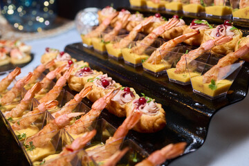 Elegant dining presentation, Sophisticated arrangement of canapes on stylish table setting, Exquisite black trays with gourmet delicacies showcased in upscale event ambiance