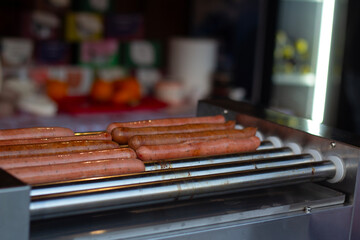Photo of process of cooking chicken, beef, pork sausages on grill on metal grate over coals at fast food cafe on New Year fair, city holiday Tbilisoba, Christmas street market, festival. Lunch, dinner