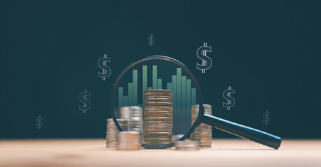 Financial growth and investment analysis concept. Magnifying glass focusing on stacked coins with bar chart and dollar symbols. Profit, wealth management, savings and business success strategy.