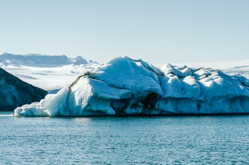 Majestic blue icebergs floating in Jokulsarlon Glacier Lagoon, Iceland, with snow-covered mountains in the background
