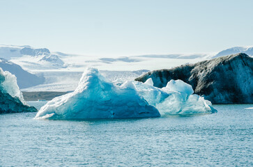 Majestic blue icebergs floating in Jokulsarlon Glacier Lagoon, Iceland, with snow-covered mountains in the background