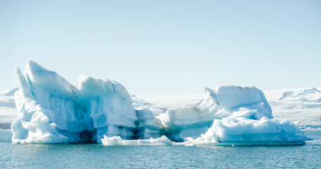 Majestic blue icebergs floating in Jokulsarlon Glacier Lagoon, Iceland, with snow-covered mountains in the background