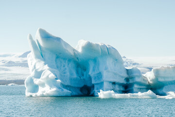Majestic blue icebergs floating in Jokulsarlon Glacier Lagoon, Iceland, with snow-covered mountains in the background