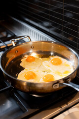 four fried eggs in a frying pan
