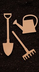 Cardboard cutouts of a shovel, watering can, and rake are neatly arranged on a dark brown soil background in a flat lay composition.