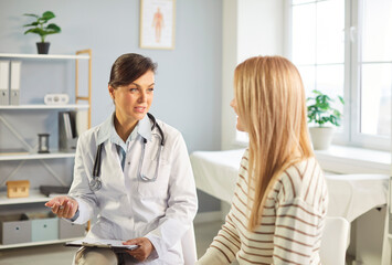 Fototapeta premium Female patient talking, consulting woman gynaecologists, endocrinologists, GP specializing in female care health, anti-ageing, family planning in clinic, hospital visit in feminist medical center