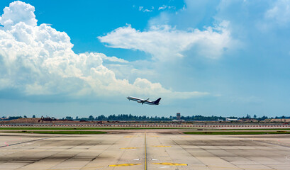 Passenger jet taking off from an International Airport under dramatic clouds