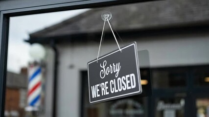 Sorry We're Closed Sign on Barbershop Glass Door with Reflective Barber Pole and Street View, Indicating Business Interruption