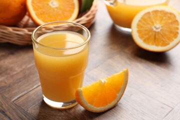 Fresh orange juice and fruits on wooden table, closeup