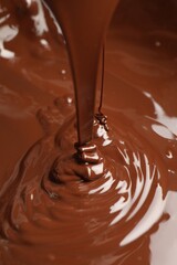 Tasty melted chocolate flowing down, closeup view