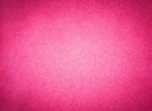 Pink color paper background texture. Sheet of bright fuschia stained arts and crafts cardboard with rough discoloured textured grain surface.