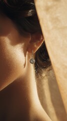Elegant Close-Up of a Woman's Ear Showcasing a Dazzling Pendant Earring Illuminated by Soft Natural Light Through Sheer Fabric