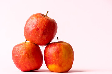stack of red apples on a light pink background
