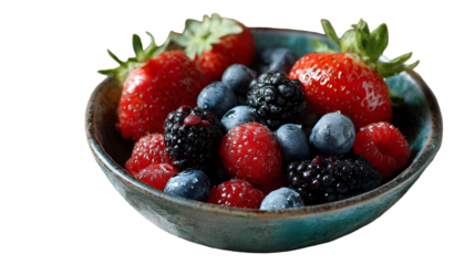 Freshly washed mixed berries including strawberries blueberries and raspberries served in a rustic blue ceramic bowl on black