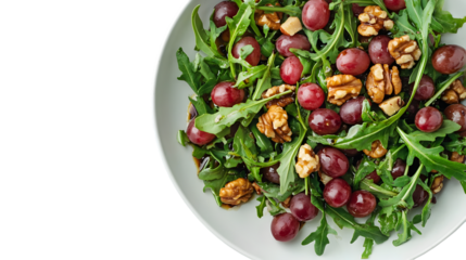 Fresh arugula salad with sweet red grapes and crunchy walnuts drizzled with dark balsamic glaze on white plate