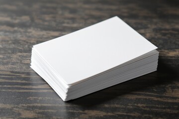 Fototapeta premium Blank business card stack on dark wooden table, clean stationery mockup with copy space, minimalist branding template for corporate identity and networking 