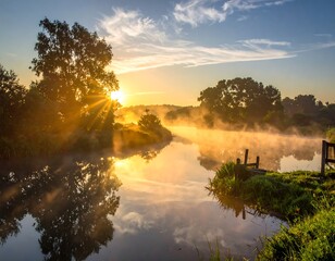 A vibrant sunrise casts golden light over a misty river