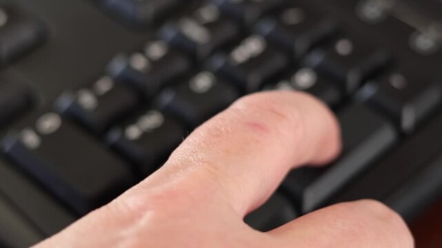 Un primer plano de un teclado con n&uacute;meros con el dedo de una mujer adulta marcando los n&uacute;meros con algo de desenfoque