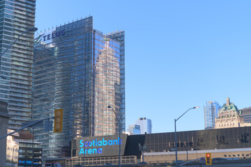 Fototapeta premium reflection of TD Canada Trust Tower on the east elevation of the Telus Building with view of Scotiabank Arena on a blue sky in Toronto