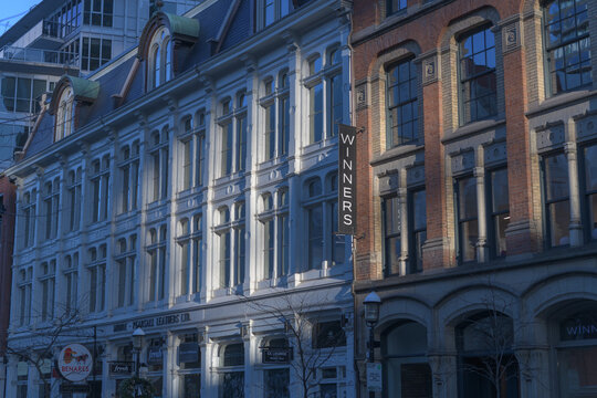 facade of historic buildings incl projecting banner sign of Winners, a department store, located at 45 Front St E, Toronto