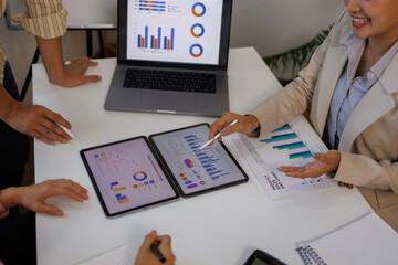 Business people, meeting and above with documents, financial review, discussion and graphs at office. Men, women and paperwork with laptop, charts and space with feedback for revenue stats at company
