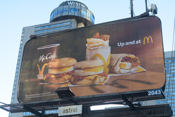 Naklejka premium traditional roadside billboard featuring advertisement by McDonald's Canada Café located on Queens Quay W with view of The Westin Harbour Castle hotel, Toronto