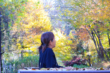 晩秋の森の中のシニア女性