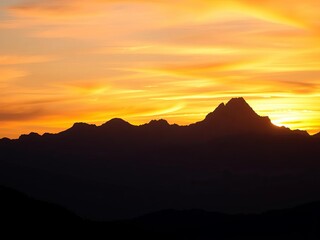Mountain range silhouetted against a dramatic, colorful sunset sky,  twilight,  dramatic