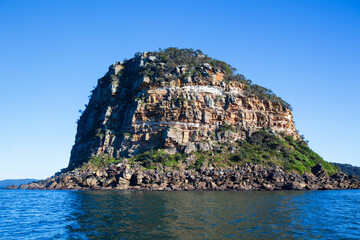 Front view of the iconic Lion Island located at the entrance of the Hawksbury River on the NSW Central Coast. Captured from the water looking west on a blue sky sunny day.