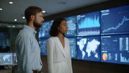 Business team analyzing data on screens in modern control center - Powered by Adobe