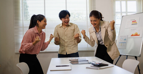 Team of asian business team creative businesspeople coworker in office Happy to be successful partnership teamwork celebrating achievement and success concept.

