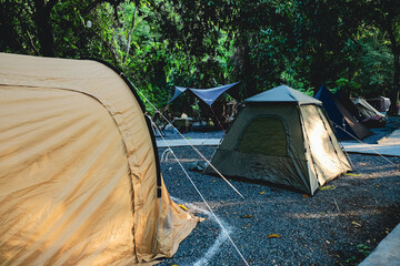 Multiple tents at shaded forest campsite in Malaysia